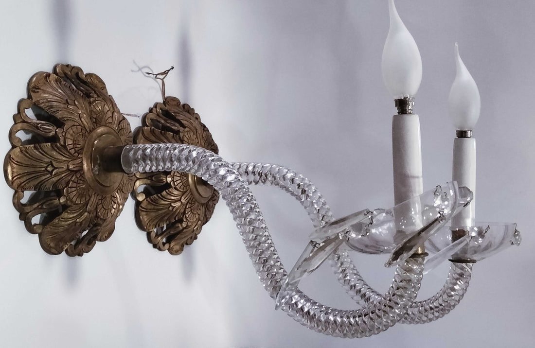 Antigua pareja de apliques de cristal de roca y metal electrificados con brazos curvos y detalles tallados, ideales para decoración de lujo en pared.