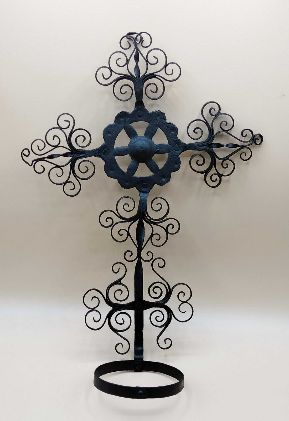 Porta decorativa maceta de filigrana cruz, vintage, en hierro forjado con diseño ornamental ideal para decoración de interiores o jardín.