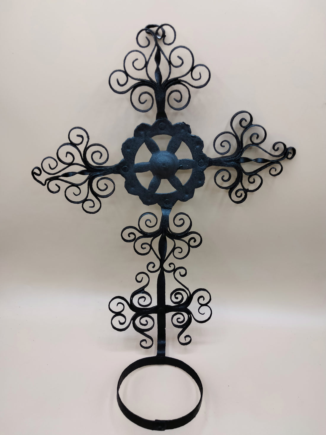 Porta decorativa maceta de filigrana cruz, vintage, en hierro forjado con diseño ornamental ideal para decoración de interiores o jardín.