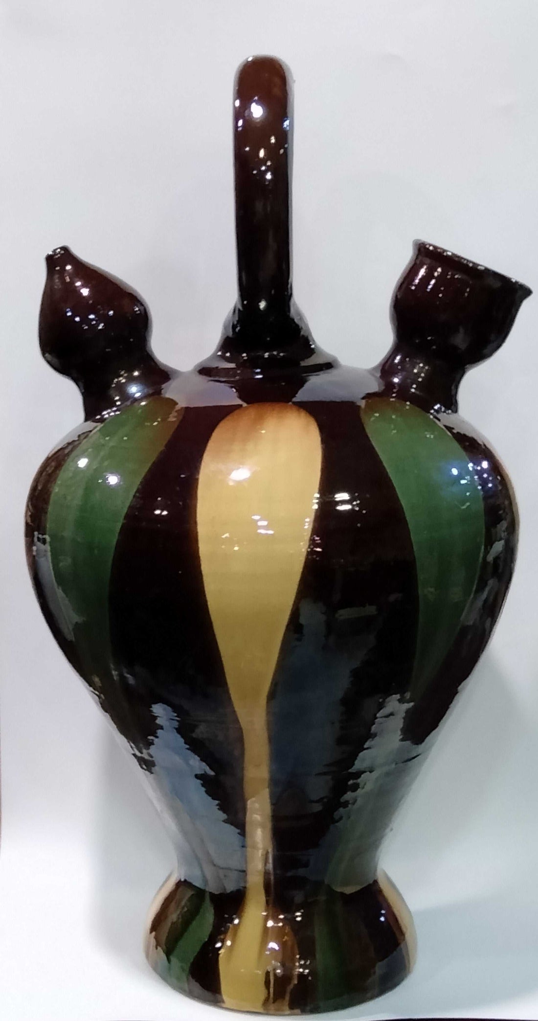 Botijo decorativo de tamaño grande con diseño pintado a mano en tonos marrón, verde y amarillo. Ideal para decoración de interiores con estilo rústico.