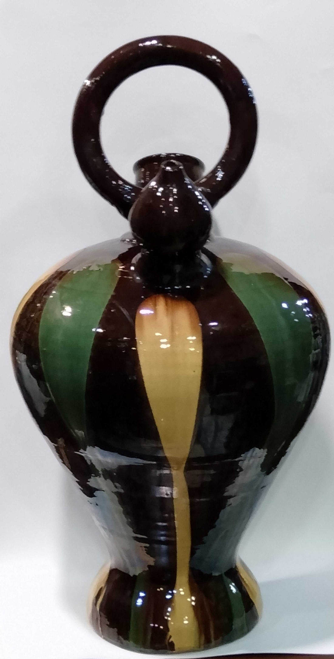 Botijo decorativo de tamaño grande con diseño pintado a mano en tonos marrón, verde y amarillo. Ideal para decoración de interiores con estilo rústico.