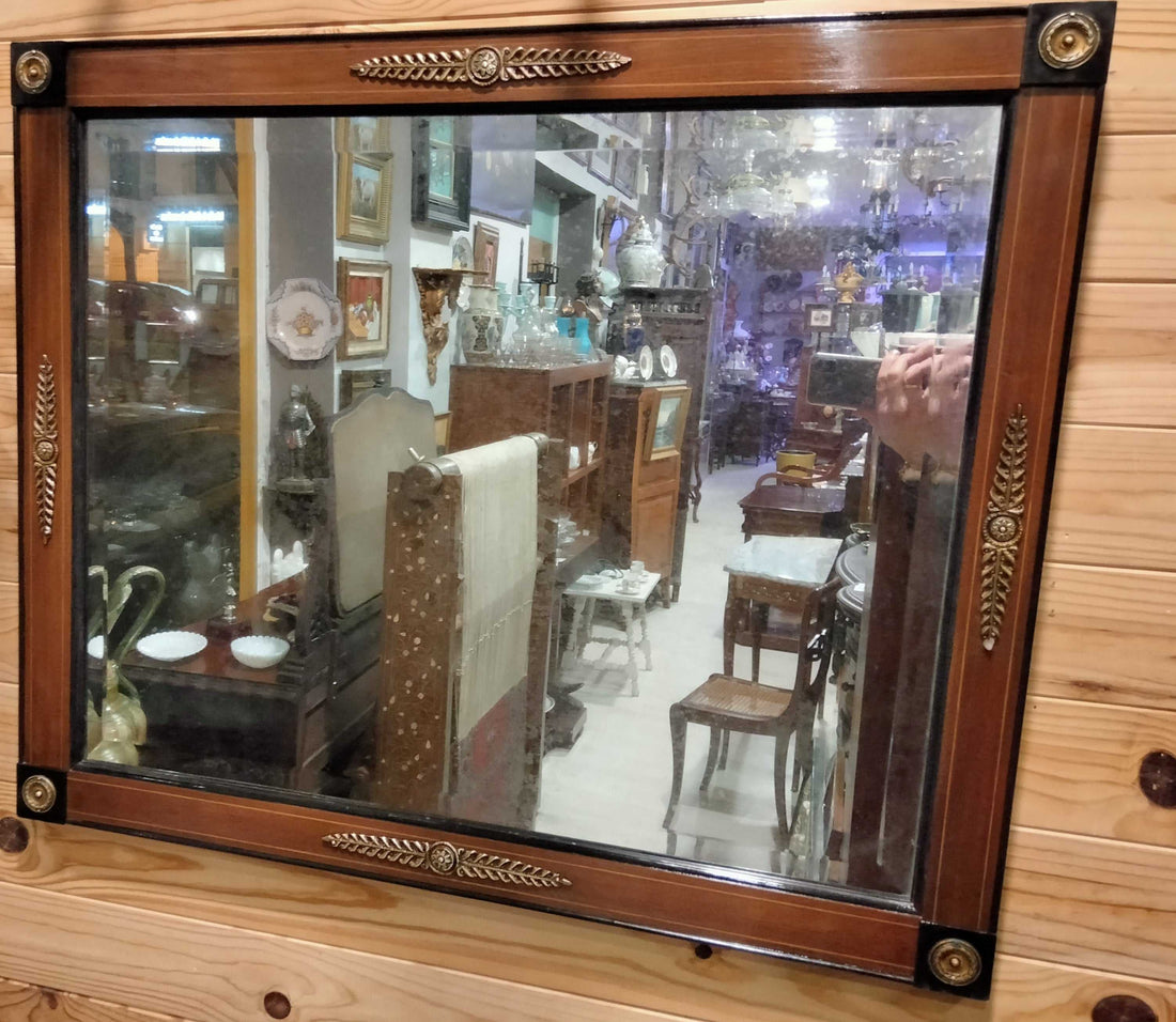 Espejo biselado de caoba con detalles en metal dorado, estilo antiguo, ideal para decoración vintage en hogar o colección de antigüedades.