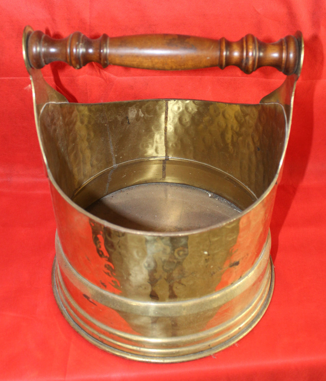 Revistero/leñera de metal resistente y elegante - vintage con acabado martillado en latón y asa de madera, ideal para decoración rústica.