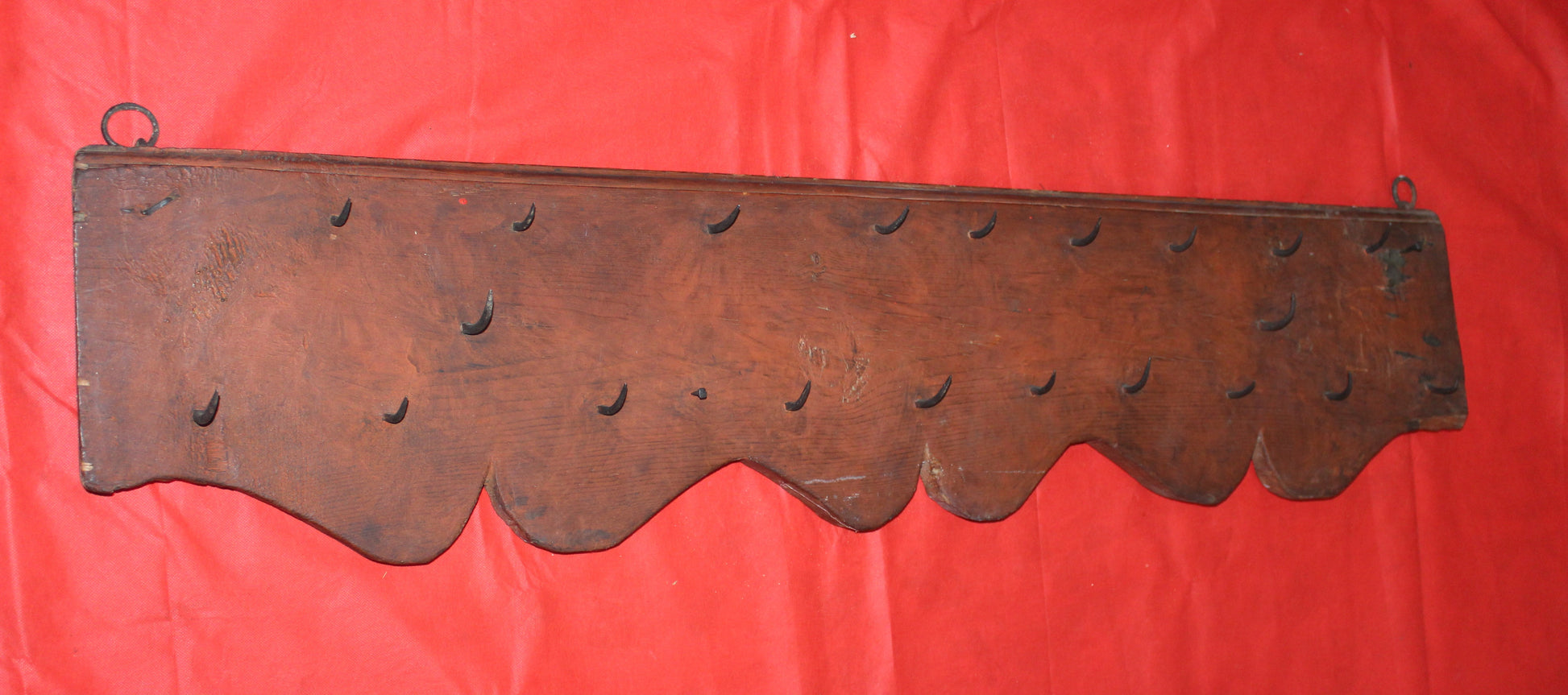 Percha antigua de matanzas con clavos de fragua, estilo rústico, hecha de madera oscura con ganchos forjados a mano. Ideal para decoración vintage en cocinas o salones de estilo rural.