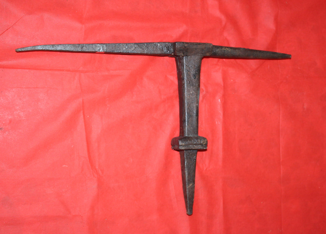 Yunque de latero en hierro forjado sobre fondo rojo, herramienta antigua para reparación de piezas de hojalata. Ideal para decoración vintage.