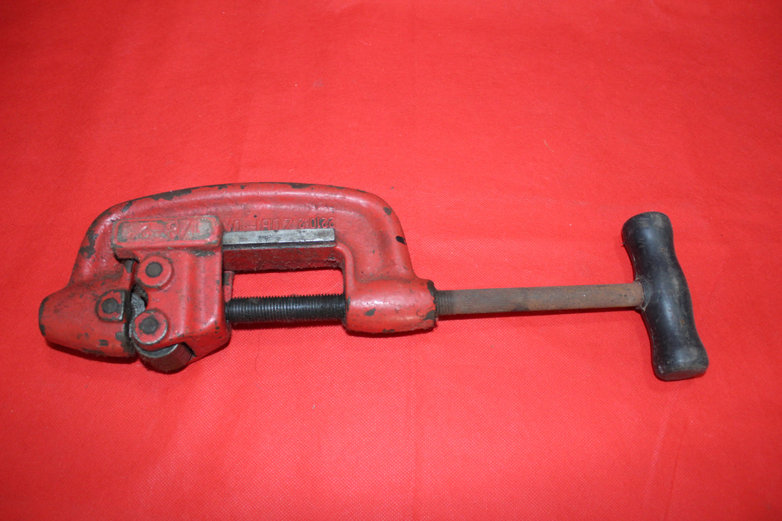 Cortatubo profesional antiguo en color rojo, ideal para cortes precisos en tuberías. Herramienta robusta y resistente para decoración vintage.