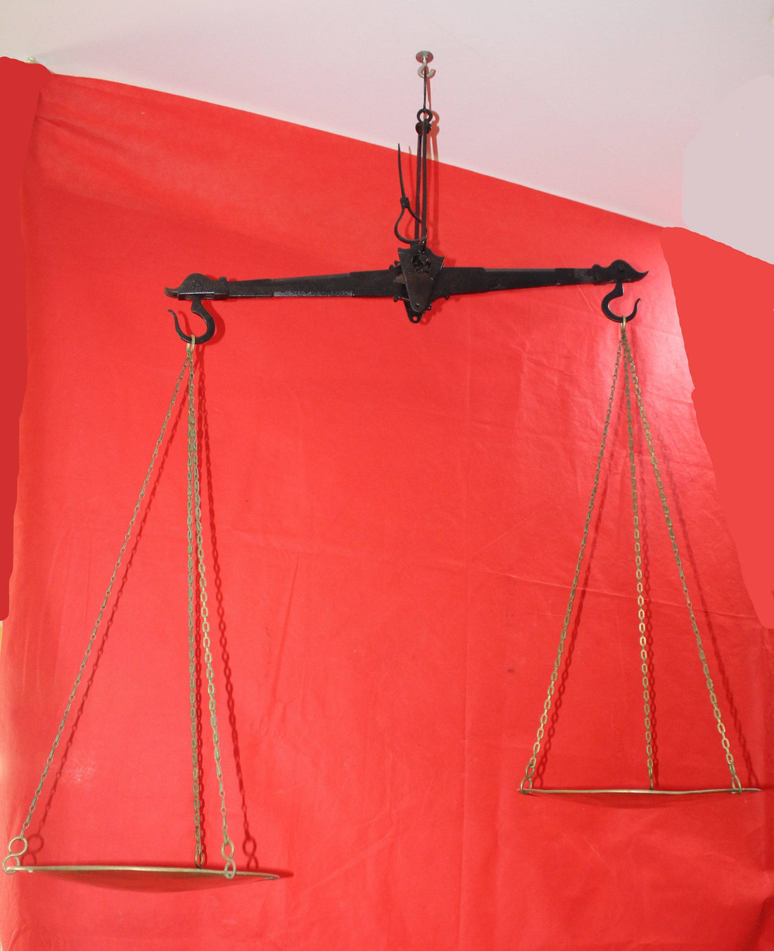 Balanza antigua de hierro con platos de metal colgante, ideal para decoración vintage en hogar o jardín. Diseño clásico y funcional en excelente estado.