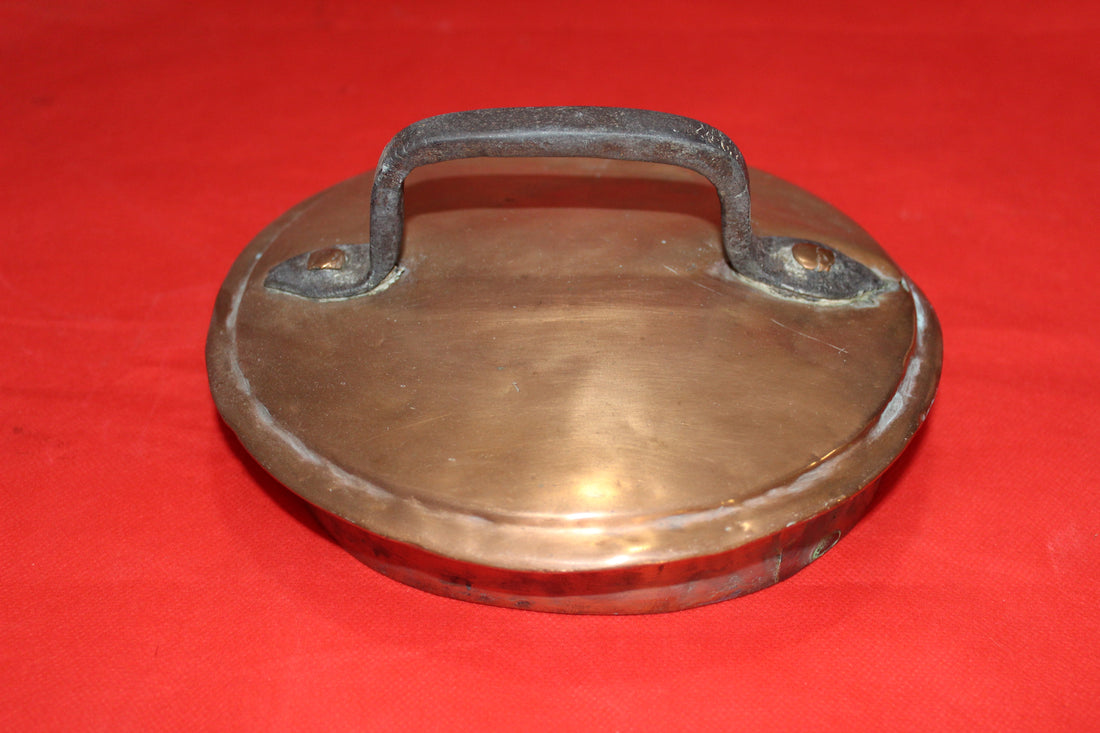Tapadera de olla de cobre con asa de hierro, estilo rústico ideal para decoración vintage en cocina o comedor. Alta calidad artesanal.