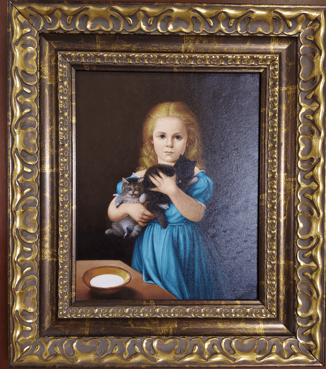 Oleo Niña con Gato - Gatos al Oleo | Arte Decorativo. Pintura al óleo de niña rubia con vestido azul sosteniendo dos gatos, enmarcada en marco dorado clásico.